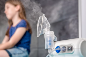 Nebulizatör cihazı ile solunum tedavisi uygulayan kişi